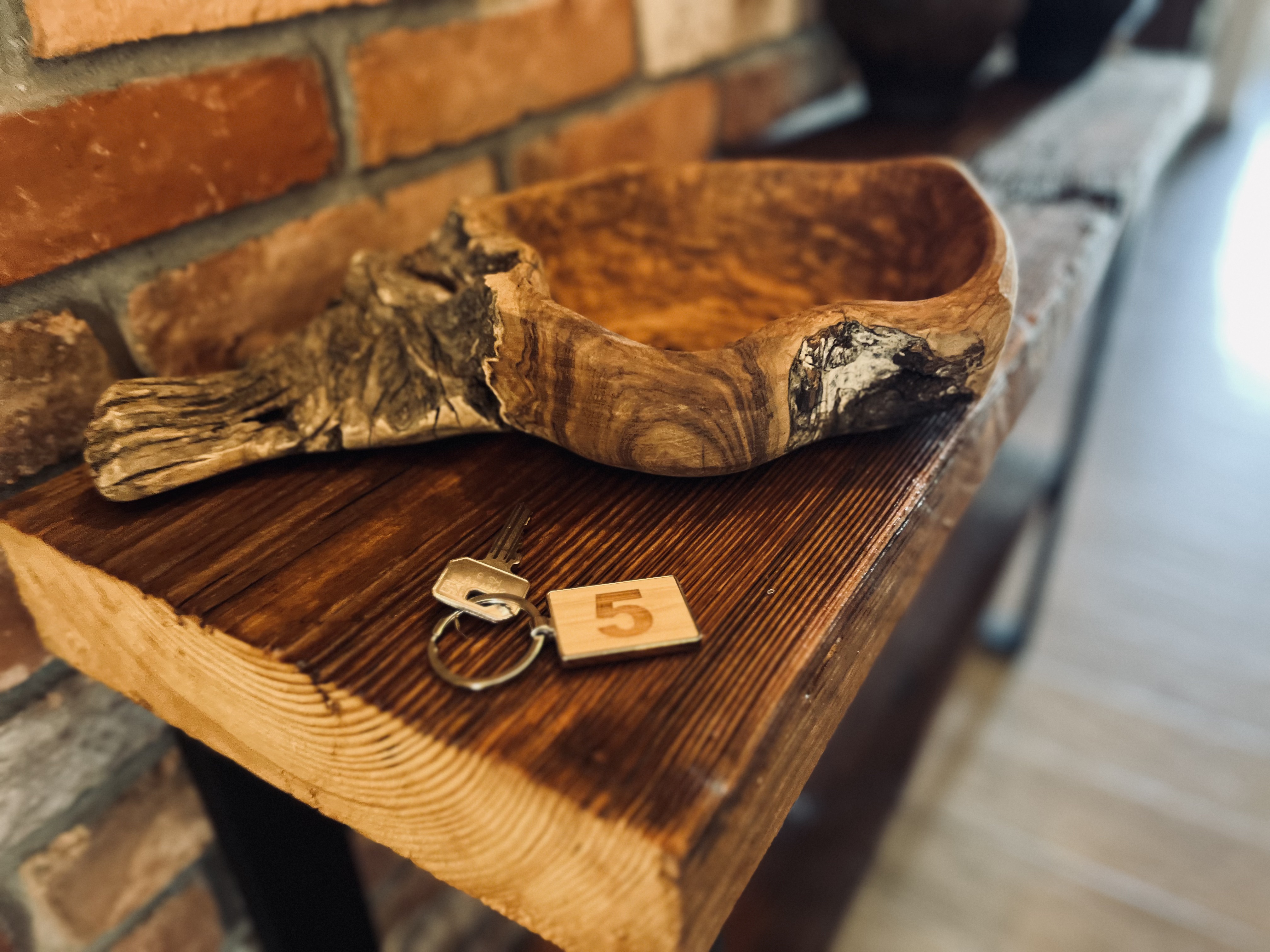 Salt&Wood Apartments — rzeźbiona misa z drewna i klucz do apartamentu